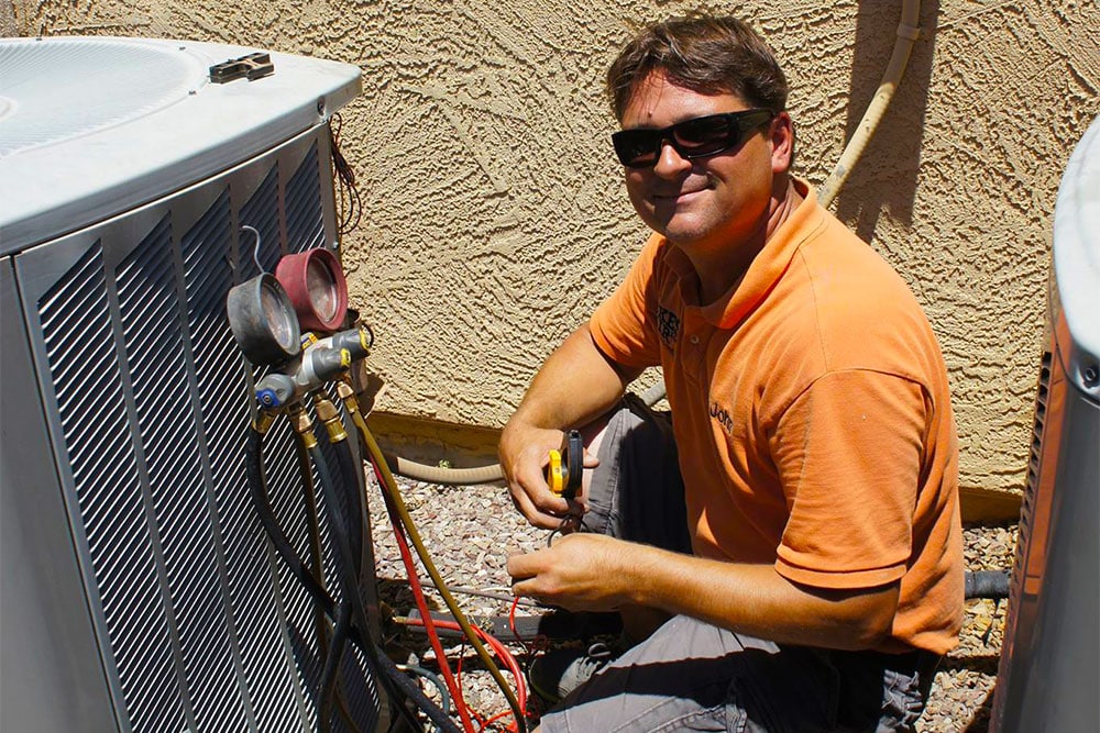 Dukes of Air Technician repairing an air conditioner