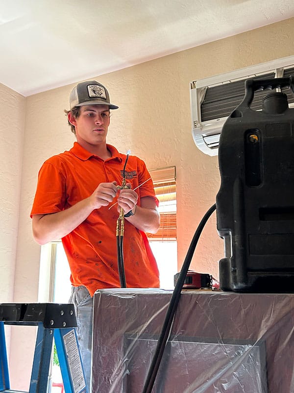 Dukes of Air ac technician repairing a mini-split air conditioning system.